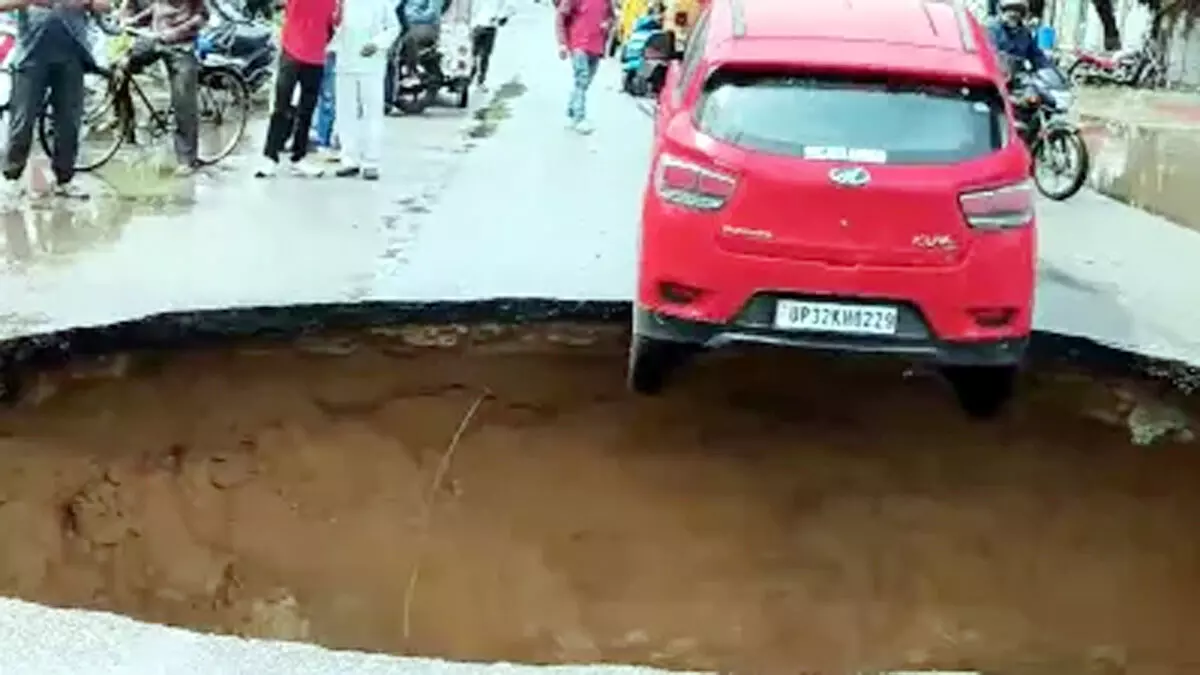 लखनऊ में बारिश से धंसी सड़क गड्ढे में फंसी कार ,जारी हुआ अलर्ट