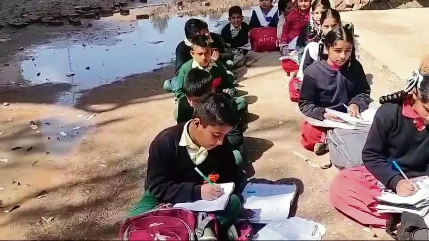सरकारी स्कूलों के छात्र नूरपुर में पठानकोट-मंडी राष्ट्रीय राजमार्ग से सटे खुले में पढ़ने को मजबूर
