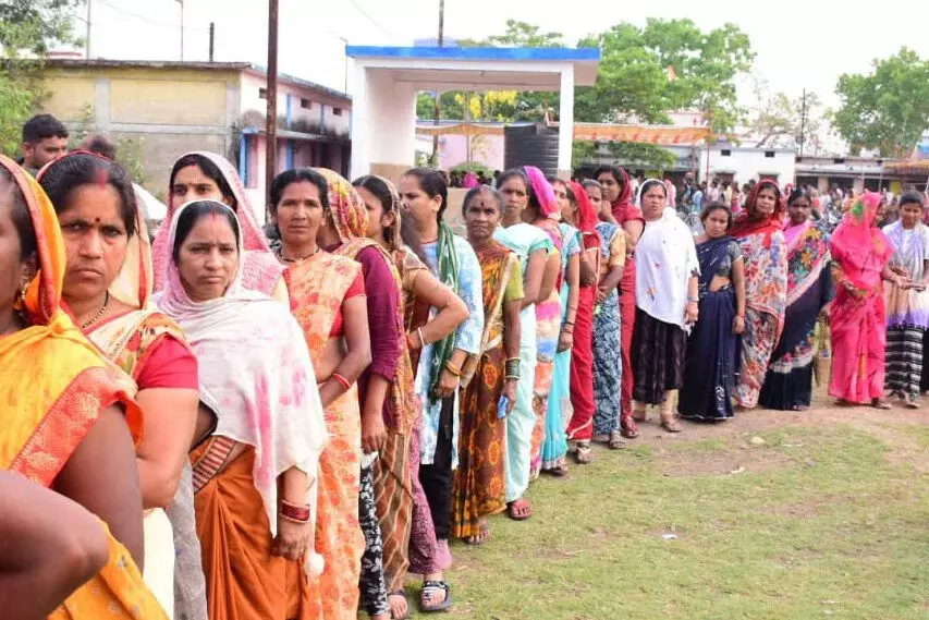 राजनांदगांव लोकसभा सीट, वोट डालने अपनी बारी का इंतजार करती हुईं महिला मतदाता