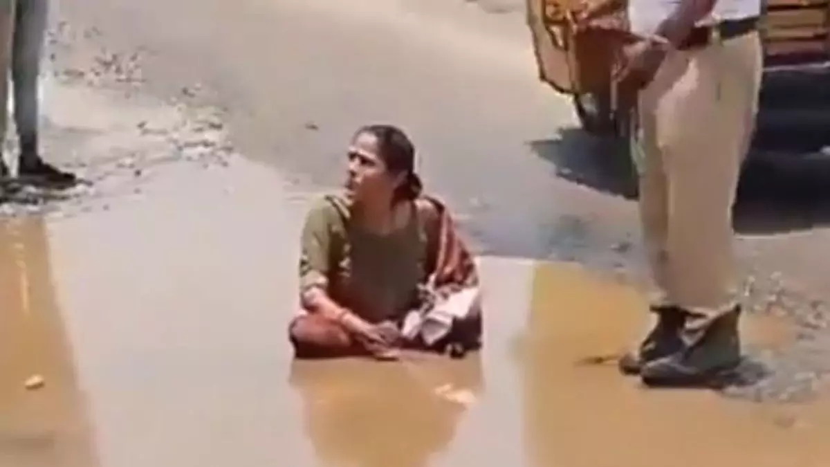 राजनीतिक कीचड़ उछाल महिला पानी से भरे गड्ढे में बैठी