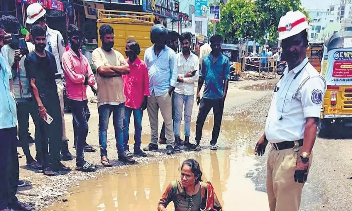 तेलंगाना में महिला गड्ढे में बैठी, तत्काल मरम्मत की मांग की