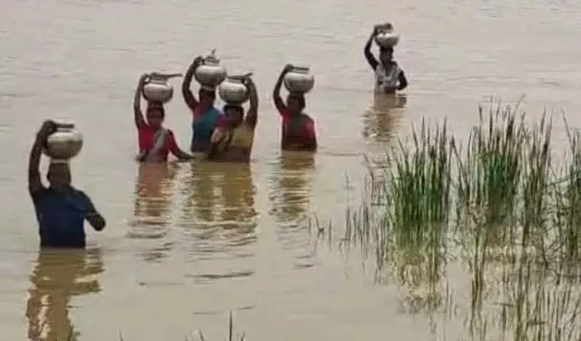 Asifabad में पीने का पानी लाने के लिए महिलाएं बाढ़ग्रस्त नदी से होकर गुजरीं