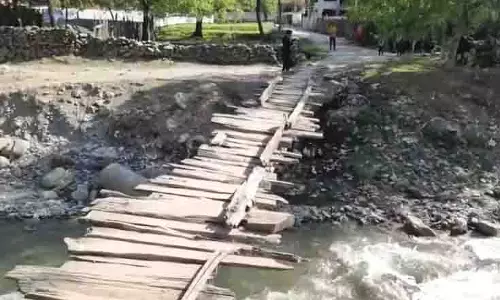 क्षतिग्रस्त लकड़ी का अस्थायी पुल हंदवाड़ा गांव के निवासियों के लिए खतरा बना हुआ