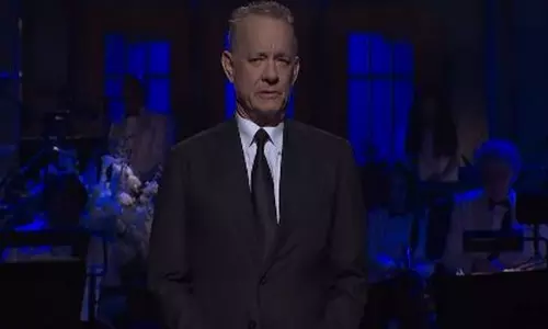 टॉम हैंक्स ने SNL की 50वीं वर्षगांठ पर व्यंग्यपूर्ण इन मेमोरियम श्रद्धांजलि दी