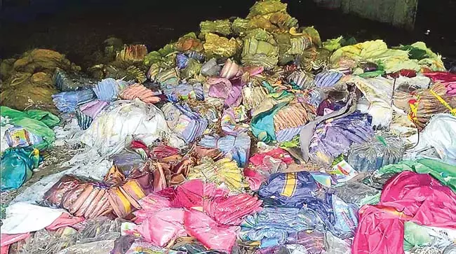 Telangana: शहर में पुराने किसानों के बाजार में साड़ियों के बंडलों के ढेर दिखाई दे रहे Telangana: शहर में पुराने किसानों के बाजार में साड़ियों के बंडलों के ढेर दिखाई दे रहे