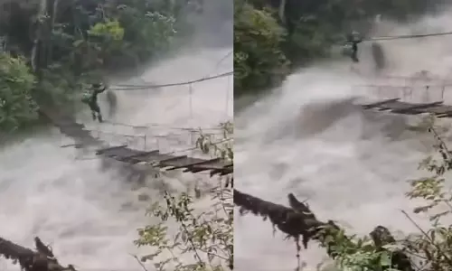 कैमरे में कैद हुई बहादुरी: उफनते पानी के बीच शख्स ने पार किया हैंगिंग ब्रिज, Video वायरल कैमरे में कैद हुई बहादुरी: उफनते पानी के बीच शख्स ने पार किया हैंगिंग ब्रिज, Video वायरल