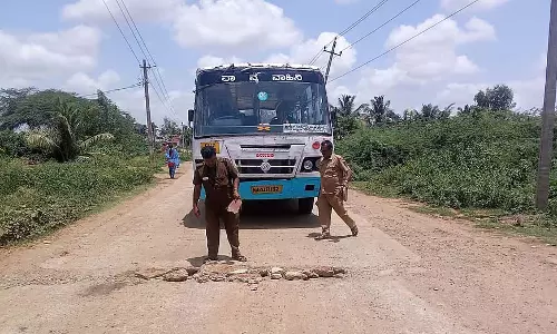 खराब सड़क; बस को निकलने देने के लिए चालक-परिचालक ने फेंके पत्थर खराब सड़क; बस को निकलने देने के लिए चालक-परिचालक ने फेंके पत्थर