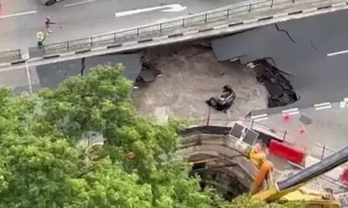 Singapore: पानी से भरे गड्ढे ने कार को निगला, महिला की नाटकीय बचाव
