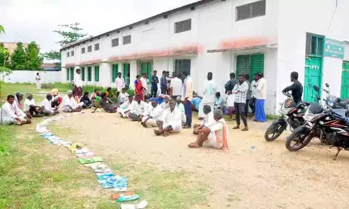 Saidapur में यूरिया के लिए कतार में जगह बनाए रखने के लिए किसान चप्पलें लेकर खड़े हुए