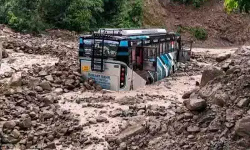 Dharampur के पास भूस्खलन के मलबे में बस आंशिक रूप से दबी Dharampur के पास भूस्खलन के मलबे में बस आंशिक रूप से दबी