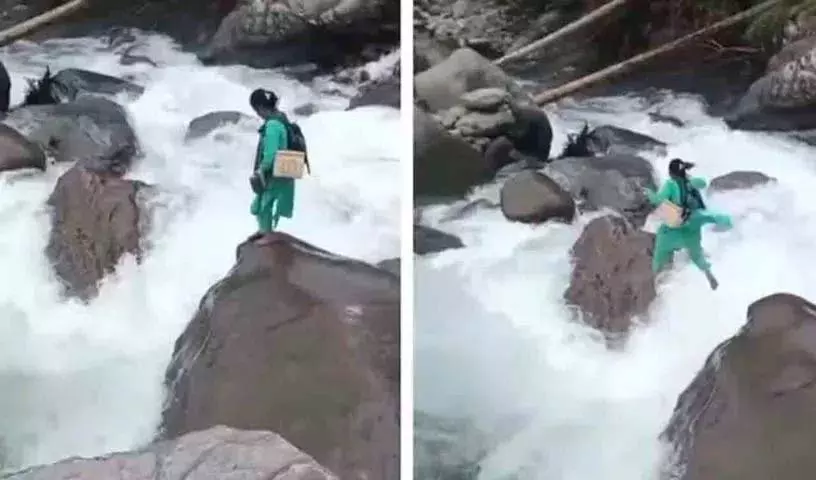 स्वास्थ्यकर्मी एक बच्चे को टीका लगाने के लिए उफनती नदी पार करता है स्वास्थ्यकर्मी एक बच्चे को टीका लगाने के लिए उफनती नदी पार करता है