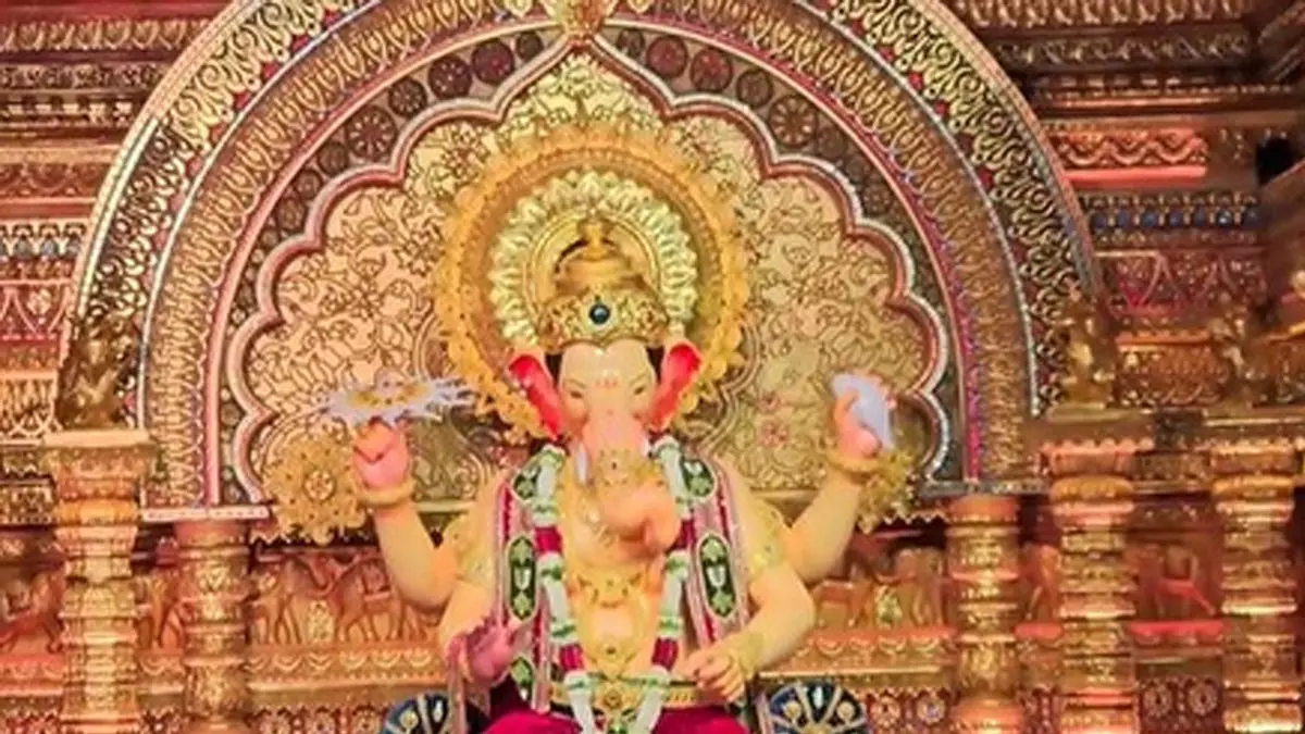 मुंबई के लालबागचा राजा की पहली झलक, हाथ में चक्र, सिर पर मुकुट और बैंगनी धोती मुंबई के लालबागचा राजा की पहली झलक, हाथ में चक्र, सिर पर मुकुट और बैंगनी धोती