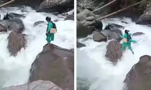 स्वास्थ्यकर्मी एक बच्चे को टीका लगाने के लिए उफनती नदी पार करता है