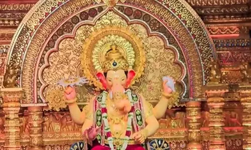 मुंबई के लालबागचा राजा की पहली झलक, हाथ में चक्र, सिर पर मुकुट और बैंगनी धोती मुंबई के लालबागचा राजा की पहली झलक, हाथ में चक्र, सिर पर मुकुट और बैंगनी धोती