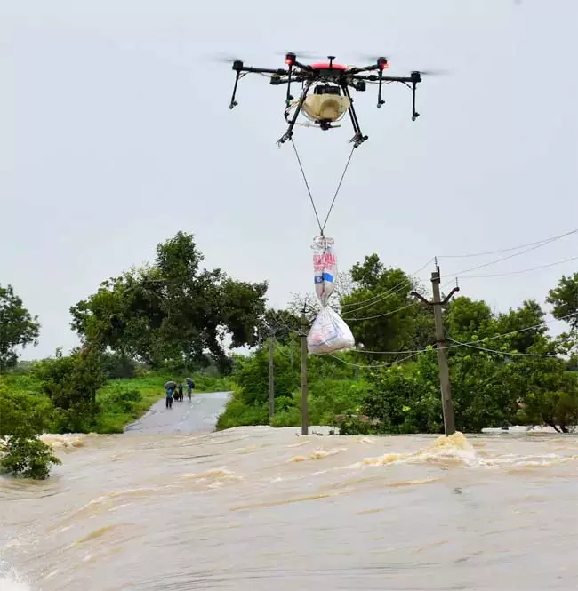 बाढ़ के पानी में फंसे लोगों तक ड्रोन की मदद से पहुंचाया गया खाना बाढ़ के पानी में फंसे लोगों तक ड्रोन की मदद से पहुंचाया गया खाना