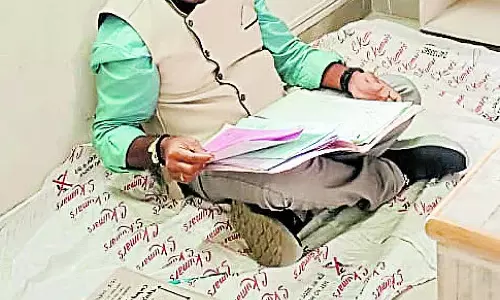 जातिगत भेदभाव के आरोप: तुमुल में फर्श पर बैठकर काम करने वाले कर्मचारी जातिगत भेदभाव के आरोप: तुमुल में फर्श पर बैठकर काम करने वाले कर्मचारी