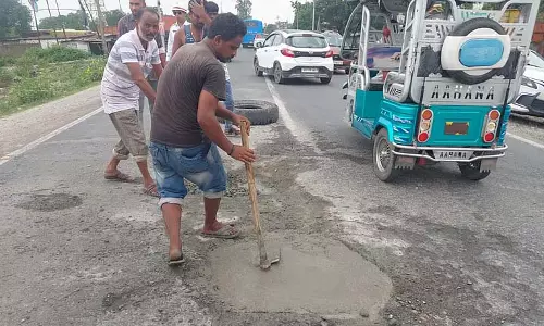 गड्ढों से भरे राष्ट्रीय राजमार्ग पर स्थानीय लोगों ने अपने खर्चे पर गड्ढे भरे