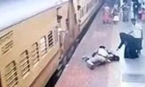 एक गार्ड ने एक जवान औरत को बचाया जो चलती ट्रेन में चढ़ने की कोशिश करते समय गिर गई थी एक गार्ड ने एक जवान औरत को बचाया जो चलती ट्रेन में चढ़ने की कोशिश करते समय गिर गई थी