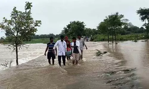 प्रसव पीड़ा से कराह रही एक महिला को बाढ़ में नाले के पार ले जाया गया