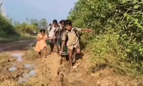 AP: विजयनगरम में आदिवासी बच्चे कीचड़ भरे रास्तों से स्कूल पहुंचते AP: विजयनगरम में आदिवासी बच्चे कीचड़ भरे रास्तों से स्कूल पहुंचते