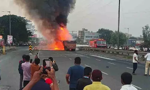 दो जलते ट्रकों के बीच कार फंसने से यात्रियों के फंसे होने की आशंका