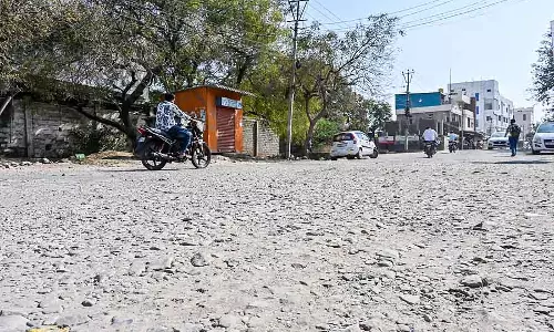 डामर गायब हो गया है; सिर्फ गड्ढे और धूल ही दिख रही है डामर गायब हो गया है; सिर्फ गड्ढे और धूल ही दिख रही है