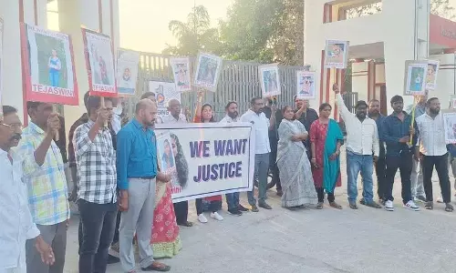 तेजस्विनी के परिवार के सदस्य Basara Triple IT के सामने प्रदर्शन कर रहे तेजस्विनी के परिवार के सदस्य Basara Triple IT के सामने प्रदर्शन कर रहे