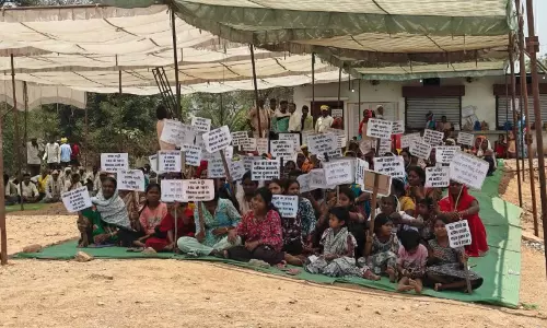शराब दुकान के सामने बच्चों को लेकर बैठे ग्रामीण, बंद करने की मांग