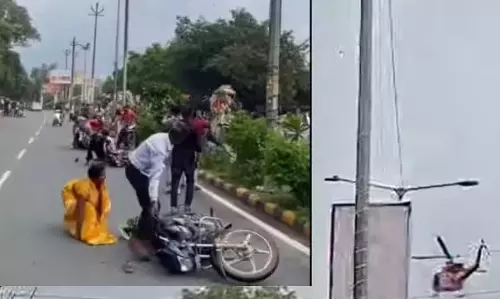हेलीकॉप्टर की तेज हवा से सड़क पर अफरा तफरी, बाइक सवार गिरे